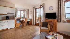 A cozy room with a dining area, a TV, and a view of the outdoors.