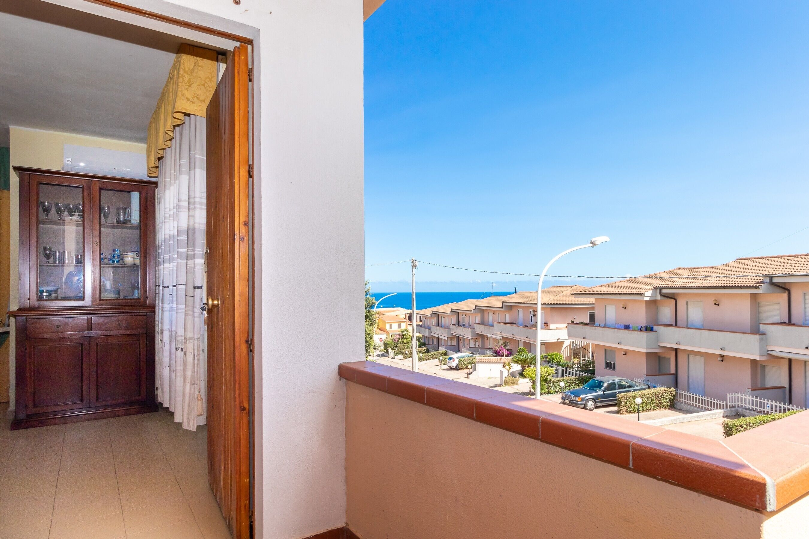 Un balcone con vista su una zona residenziale e sul mare.