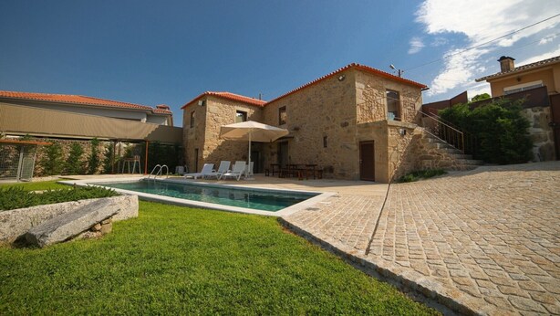 A stone building with a swimming pool, outdoor seating, and a staircase leading to a second level. - Pet-friendly Vacation Home Villae Carreiro with Pool, A/C, Wi-Fi, Garden & Terrace (Braga)