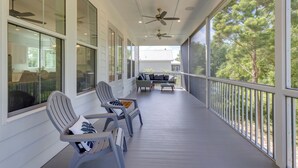 Een overdekte veranda met twee stoelen, een tafel en een bank.