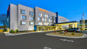 Un hôtel moderne doté d’une entrée imposante et d’un espace de stationnement.