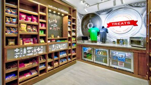 Un magasin de snacks avec des étagères remplies de diverses friandises et un comptoir sur lequel est affiché un panneau indiquant « GÂTERIES ».
