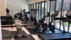 Una palestra con tapis roulant, ellittiche e manubri.