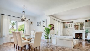 Amplia sala de estar con mesa de comedor, sillas, sofá y chimenea.