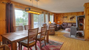A cozy cabin interior with a dining area, a living room, and a fireplace.