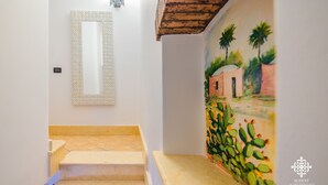 A staircase with a textured wall and a painting of a landscape with palm trees.