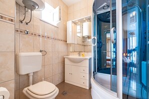 Ein Badezimmer mit Toilette, Waschbecken und Dusche.