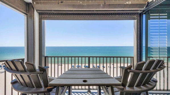 A balcony with a view of the beach and ocean.