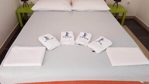 A neatly made bed with white linens and pillows, two bedside tables with lamps, and a green accent wall. - Apartment Manuel With 1 Bedroom With Terrace and sea View (Omisalj)