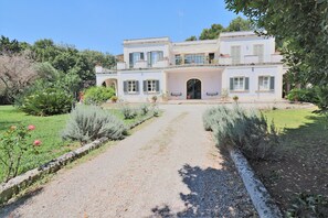 A two-story building with a garden pathway leading to the entrance.