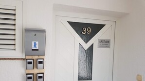 A white door with the number 39, a sign indicating it's an apartment, and a keypad lock system. - Room Mira With Terrace and sea View (Omisalj)