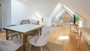 A spacious loft apartment with a high ceiling, a dining area with a marble table, and a cozy seating area with a sofa and chairs. - Regent 9 - Great Apt With Terrace in City Centre (Copenhagen)