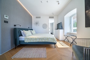 A modern bedroom with a bed, a desk, and a window. - Villa Lastva is a Five Star Seafront Luxury Villa With Privite Pool (Tivat)