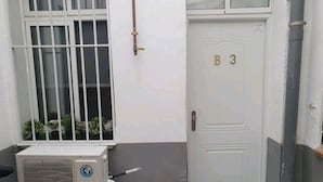 A white door with the number B3, a window with metal bars, and an air conditioning unit. - Studio in the Center of Madrid (Madrid)