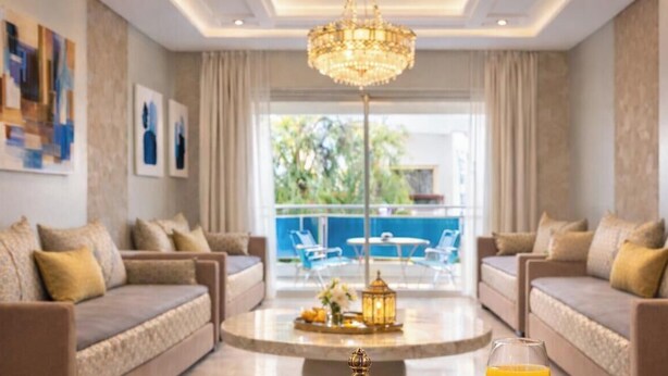Un salon moderne avec deux canapés, une table basse et un lustre.