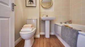 Un baño con inodoro, lavabo y bañera.