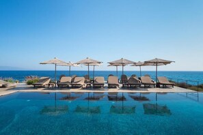 Una piscina al aire libre de temporada, sombrillas