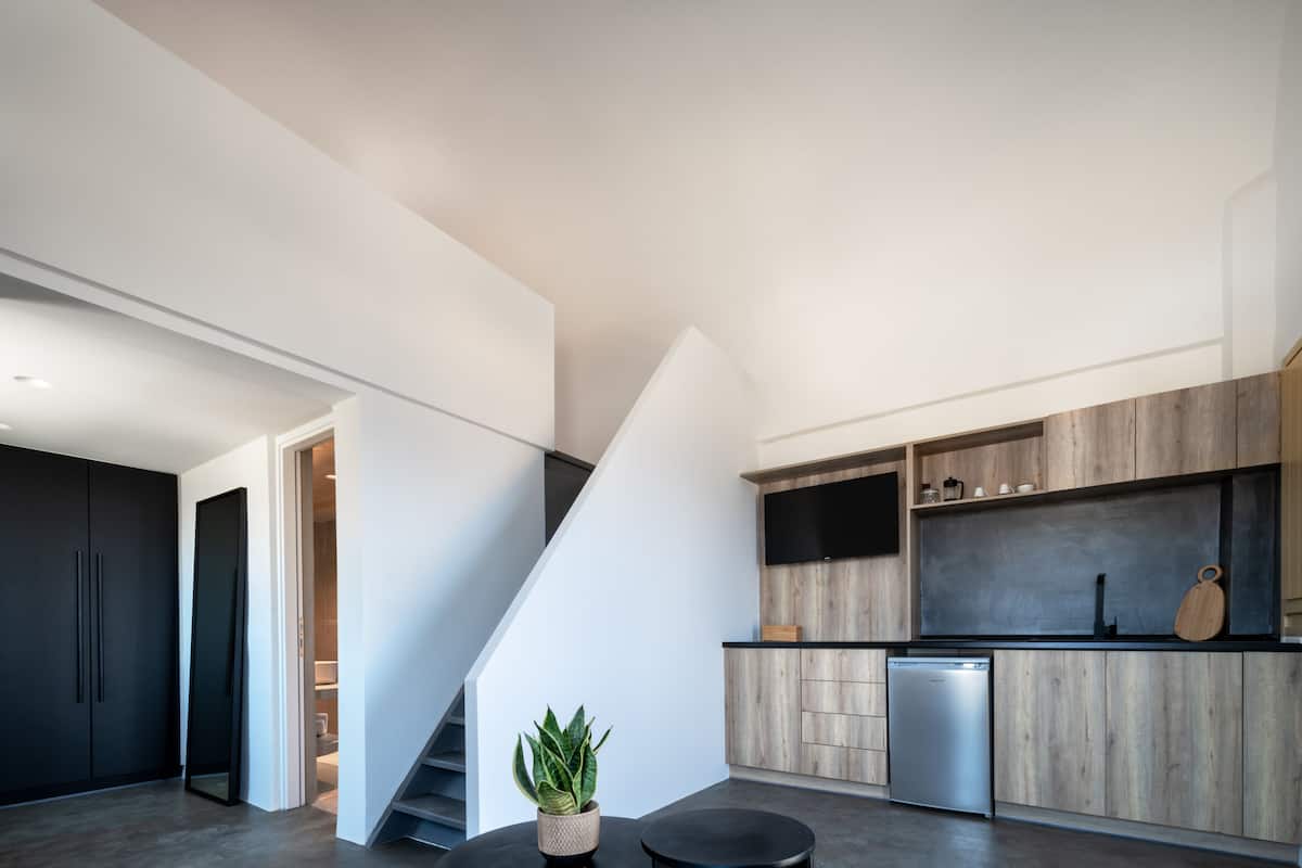 A modern kitchen with a built-in stove, a sink, and a countertop. There is a staircase leading to another level.