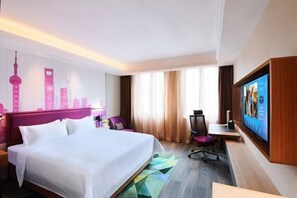 A hotel room with a large bed, a desk, a chair, and a TV on the wall. - Hampton BY Hilton Shanghai Hongqiao Necc (Shanghai)