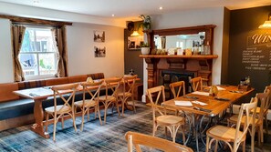 Enjoy a meal at a beautifully set dining area with a long table, comfortable seating, and a warm atmosphere.