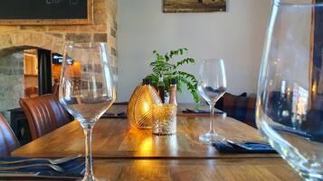 A dining table with empty wine glasses, a candle holder, and a small plant.