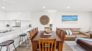 Relax in this stylish apartment with a comfortable sofa, dining table, and modern kitchen.