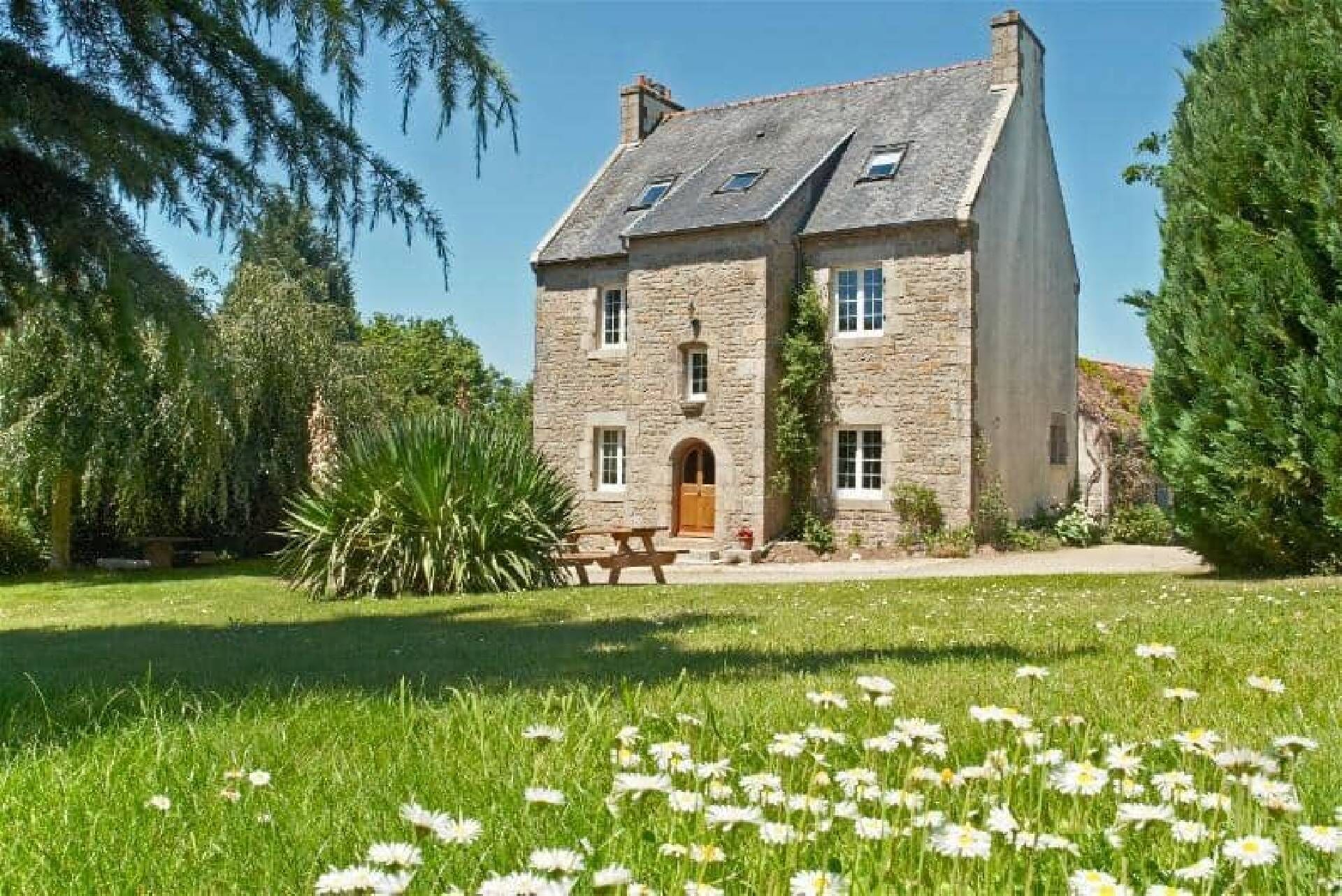 Un edificio de piedra con una entrada amplia y una mesa de picnic al frente.