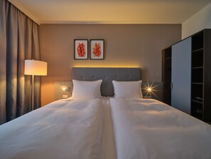 Relax in a stylish space with a large bed, floor lamp, and wardrobe.