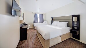 A hotel room with two beds, a desk with a lamp, a flat-screen TV, and a large mirror. - Belvilla Newport City Centre Hotel - Lifestyle (Newport)