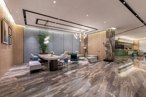 A modern interior with a marble floor, a round table with chairs, a potted plant, and a decorative sculpture.