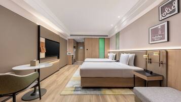 Habitación de hotel con cama, escritorio, silla, televisión y un cartel enmarcado en la pared.
