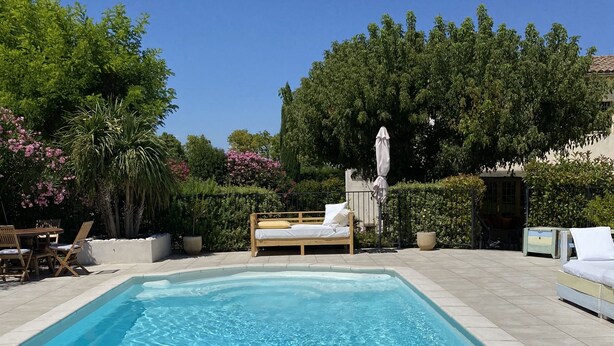 A rectangular swimming pool with a wooden deck and a bench. - Superb 250 m2 Provencal farmhouse for rent (Mas-Blanc-des-Alpilles)