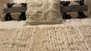 A bed with a textured blanket, decorative pillows, and two framed wall art pieces above it. - Superb 250 m2 Provencal farmhouse for rent (Mas-Blanc-des-Alpilles)