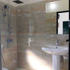 Een bad/douchecombinatie, een haardroger, een bidet, handdoeken