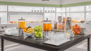 A buffet setup with various food items and beverages, including fruits, cereals, and a punch bowl. - TITANIC Comfort Kurfürstendamm (Berlin)