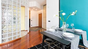 A dining area with a black and white patterned tablecloth, white plates, and a vase with white flowers. - MyHomeInComo - Santa Chiara Apartment (Como)