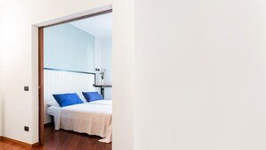 A bedroom with a bed, white walls, and a wooden floor. - MyHomeInComo - Santa Chiara Apartment (Como)