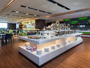 A buffet area with multiple serving stations, a variety of dishes, and a modern interior design.