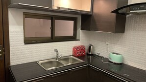 Une cuisine équipée d’un évier à deux bacs, d’un grille-pain et d’une bouilloire.