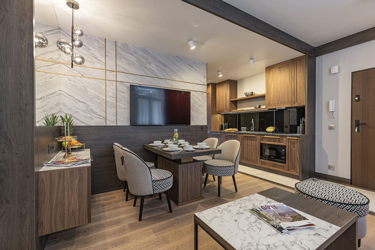 A modern kitchen with a built-in oven, microwave, and a large island with seating.