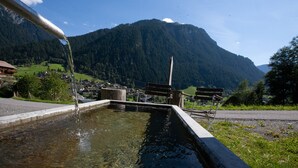 Eine Berglandschaft mit einem Wasserspiel und Bänken.