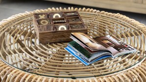 A wicker chair with a magazine and a wooden puzzle box. - AmazingApartment W Views of Achziv Beach (Nahariya)