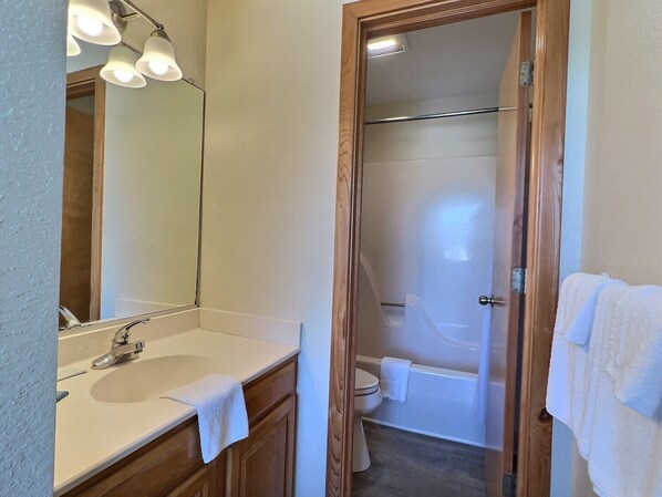 A bathroom with a sink, mirror, and shower. - Sea Horse- Oceanside- Only a short Walk to Beach- Community Pool & Spa (Buxton)