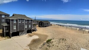 A beachfront property with multiple houses, a sandy beach, and the ocean in the background. - Sea Star- Ocean Views- Steps to Beach- Community Pool (Buxton)