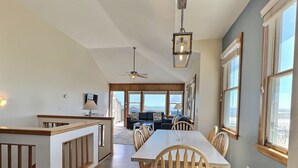A spacious dining area with a high ceiling and a view of the outdoors. - Sea Star- Ocean Views- Steps to Beach- Community Pool (Buxton)