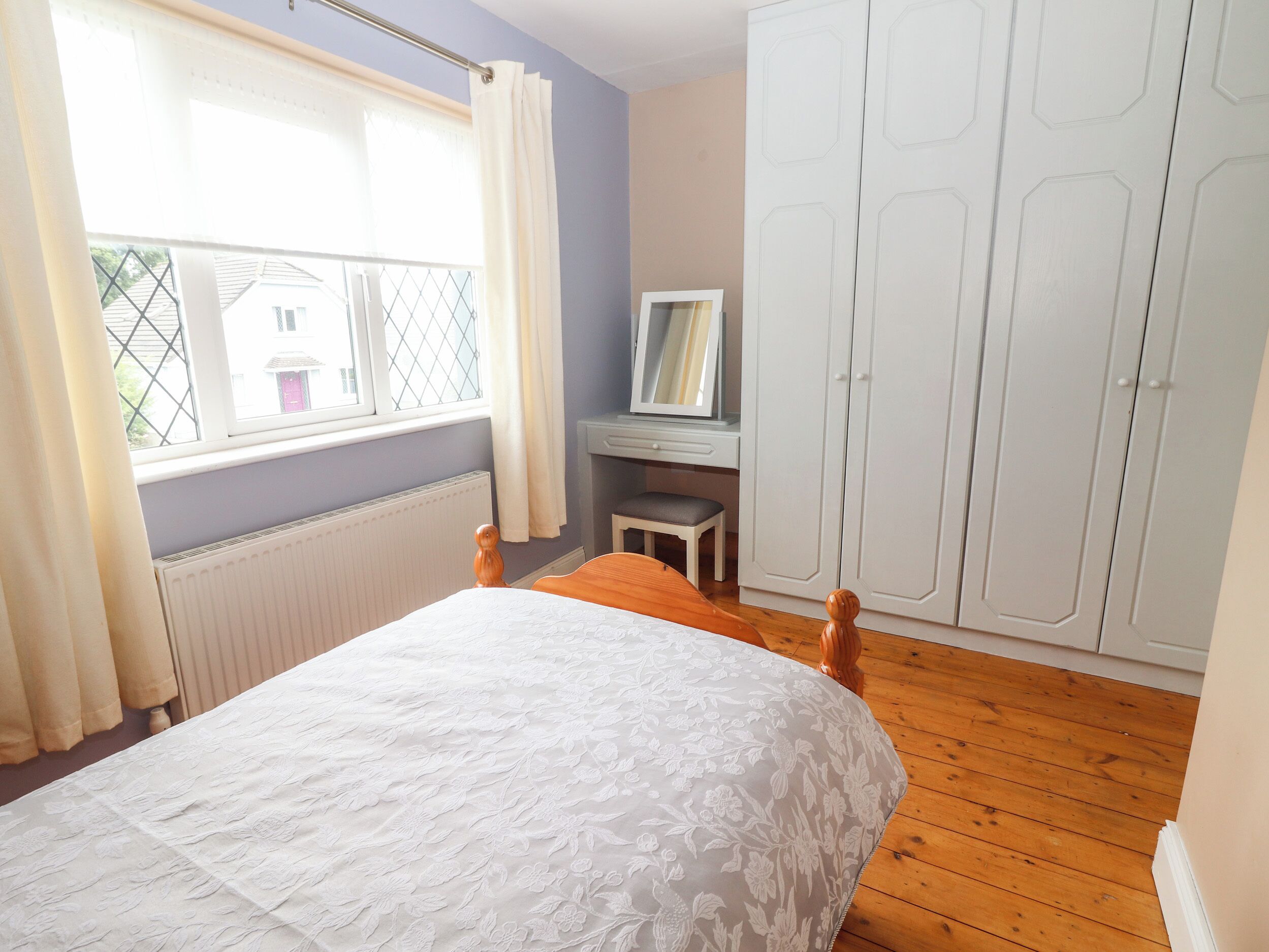 Une chambre à coucher comprenant un lit, un bureau, une chaise et une armoire.