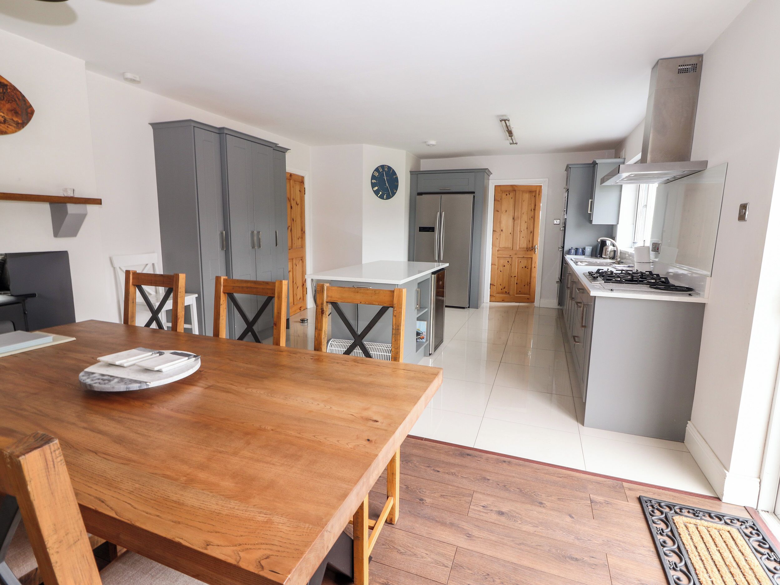 A modern kitchen with grey cabinets, a stainless steel stove, and a white countertop.