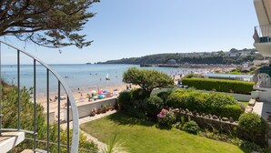 Blick auf die Küste vom Balkon mit Strand, Menschen und Booten.