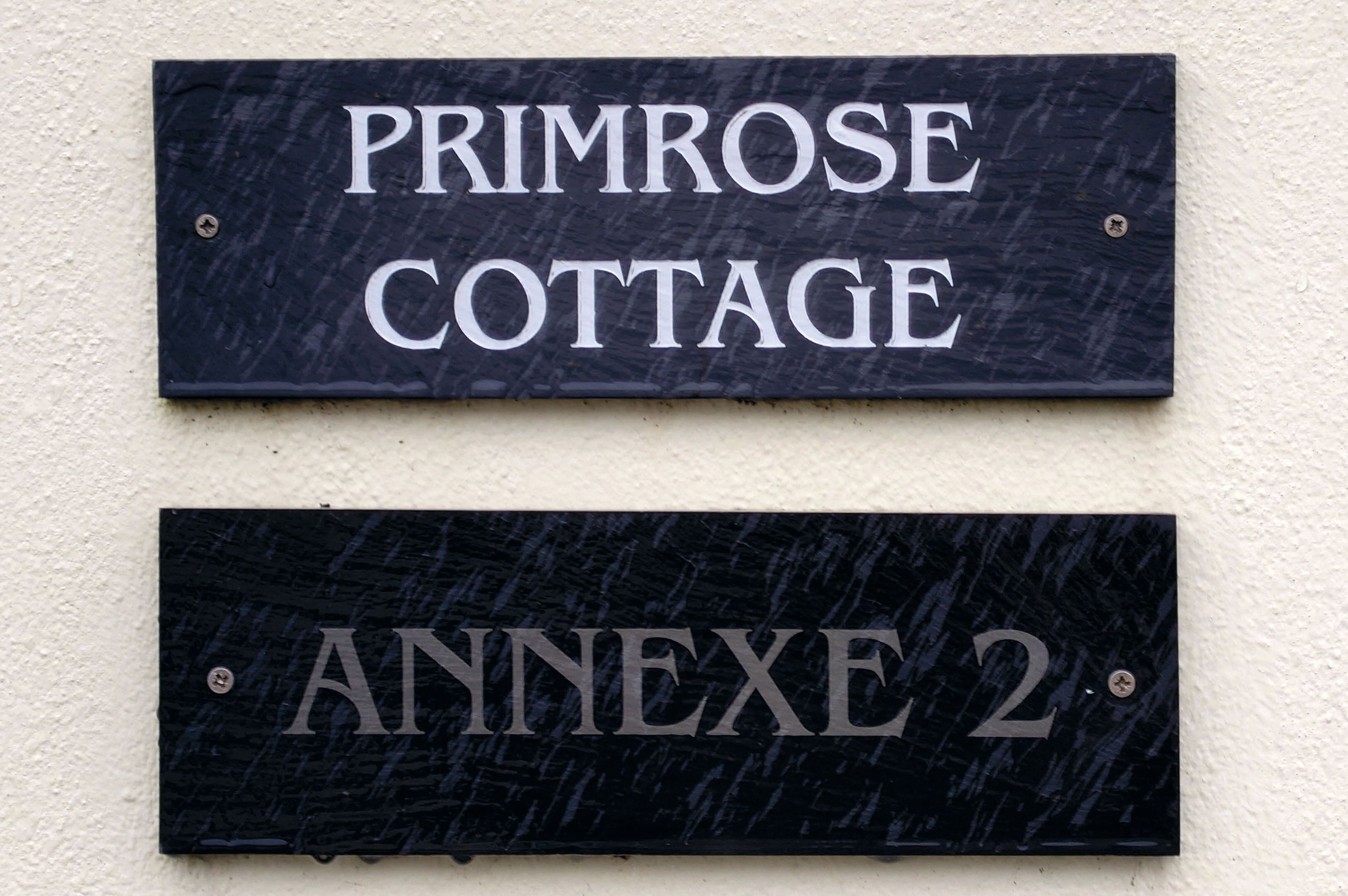 Two signs: one reads "PRIMROSE COTTAGE" and the other "ANNEXE 2".