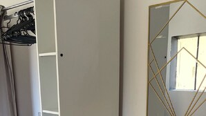 A room with a wardrobe, a mirror with geometric design, and a carpeted floor. - Maison de 50m2 Avec Piscine Commune (Fréjus)